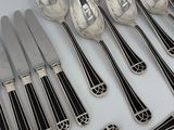 a lot of spoons and knives that are on the table
