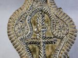 an image of a metal object with a cross on it