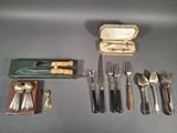 a lot of silverware on a table with a case