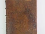 an old book is sitting on a table with a white background