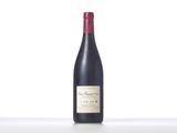 a bottle of red wine sitting on top of a white table
