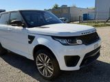 the white range rover is parked in the parking lot