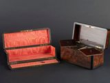pair of antique wooden boxes with leather linings on a black background