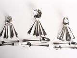 four forks, spoons, and a knife on a white surface