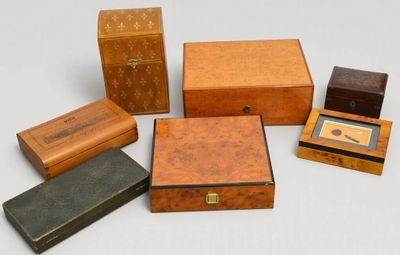 plusieurs types de boîtes et de coffrets en bois posés sur une surface blanche