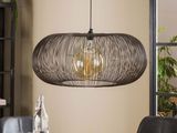 the gray wicker pendant light fixture hangs over a dining room table