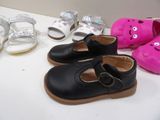 several pairs of toddler shoes are lined up on a table