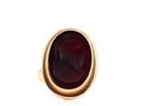 a close up of a gold ring with a red stone in it