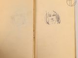 an open book with a drawing of a woman ' s face on it