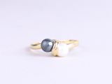 a close up of a gold ring with two pearls on it
