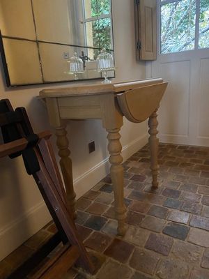 une petite table sur laquelle est posé un miroir, dans un coin de la pièce
