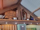 a room with a metal roof and a shelf with pots and pans on it
