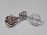 gros plan d'une paire de boucles d'oreilles sur une surface blanche
