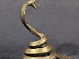 an image of a bronze sculpture of a snake on a marble base