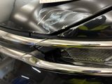 a close up of a car ' s headlight with a sticker on it
