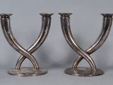 two silver candlesticks that are sitting on a table