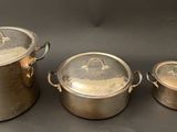 three pots with lids and lids are sitting on a table