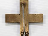 a close up of a metal cross on a white surface
