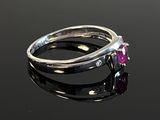 a close up of a ring with a pink stone