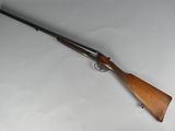 a rifle with a wooden handle on a white surface