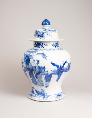un vase bleu et blanc avec un couvercle posé sur une table