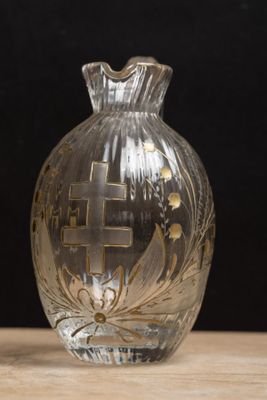 un vase en verre orné d'une croix, posé sur une table