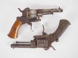 deux vieux revolvers sur fond blanc, dont l'un avec une crosse en bois