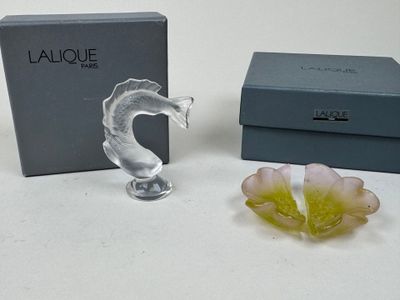 a glass figurine with a flower in front of a box