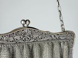 an old silver purse hanging on a chain with a chain around it
