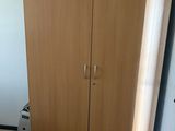 a wooden cabinet in the corner of a room