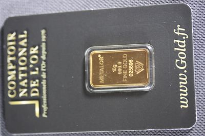 the gold bar is sitting on top of the card on the table