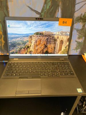 un ordinateur portable ouvert posé sur un bureau, à côté d'un clavier