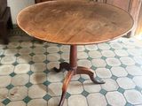a small table with a wooden top on a tiled floor