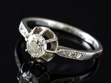 a close up of a diamond ring on a black surface
