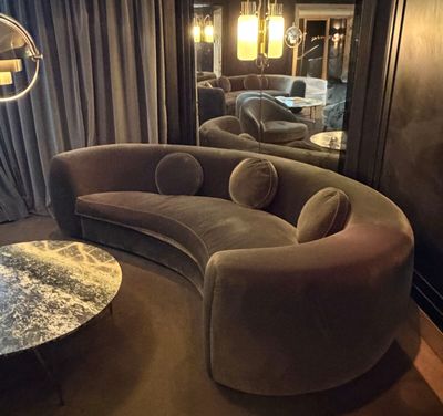 a living room with a curved couch and a round coffee table