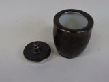 a small vase with a lid sitting on a table