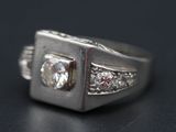 une image d'une bague en diamant sur une surface noire
