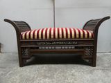 un banc en bois sur lequel est posé un coussin rayé