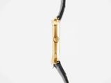 a close up of a black and gold watch on a white background