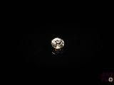un gros plan d'un diamant posé sur une surface noire dans l'obscurité