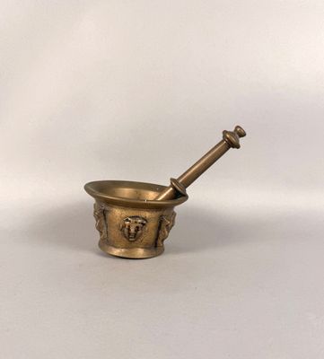 Mortier et son pilon en bronze à contreforts et têtes d'ange…