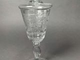 an old fashioned glass cup with a lid on a gray surface