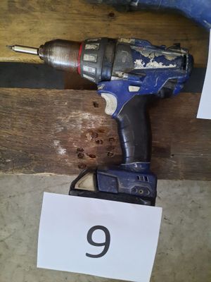 une image représentant une perceuse et un marteau posés sur un morceau de bois