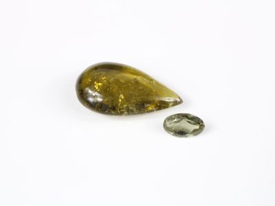 un gros plan sur un morceau de verre jaune et vert posé sur une surface blanche