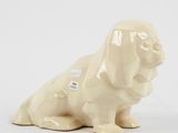 a figurine of a dog sitting on a white surface