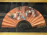une photo d'un tableau représentant un éventail, dans un cadre doré