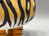 a close up of a tiger figurine on a white surface