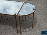 two tables with mirrored tops and brass legs on the ground