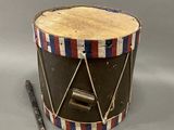 an old drum with a wooden handle and a wooden stick