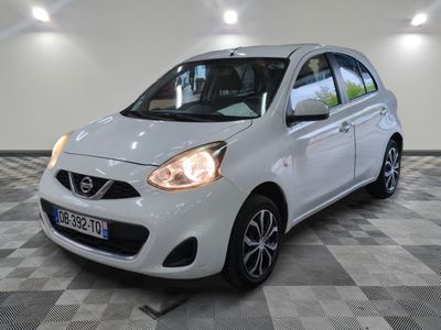 la petite voiture blanche est garée sur un sol en damier